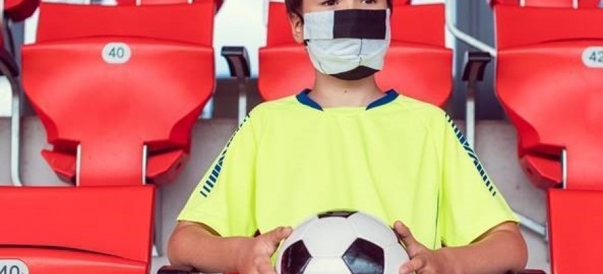 dreng med mundbind og fodbold