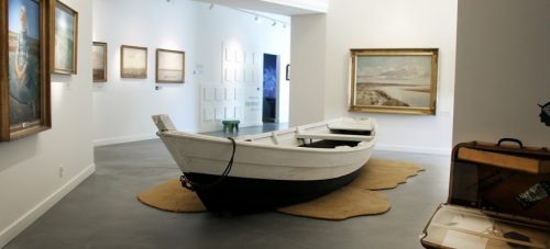 Museet vist indefra. Fokus på en båd og malerier.